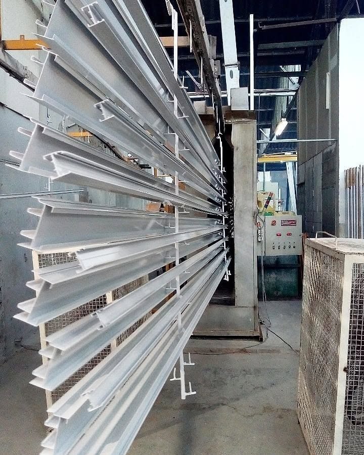 Perfiles de aluminio blancos en rack de pintado